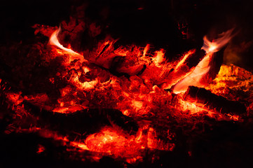 Bright colorful orange-red embers dying bonfire.