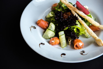 Dish in a white plate on a black background
