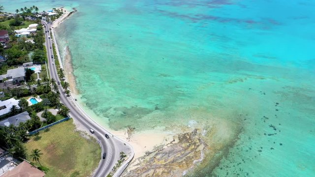 Aerial: Cars Driving on Scenic Road Next to Crystal Clear Tropical Water  - Nassau, Bahamas