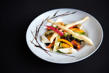 Dish in a white plate on a black background