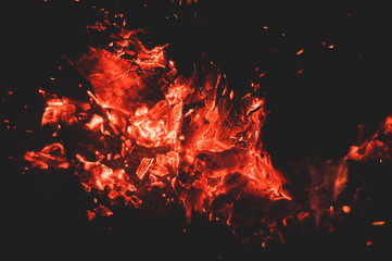Fototapeta na wymiar Glowing bright colorful orange-red embers bonfire.
