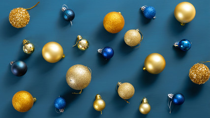 Christmas postcard with golden and blue balls over blue background. Flat lay, top view, overhead