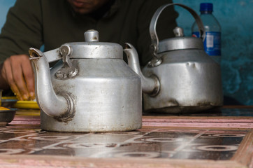 Two old aluminum kettles used to serve water in a rustic village restaurant