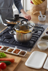 Cooking woman in kitchen with wooden spoon