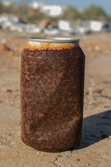 Naklejka premium rusty tin can, rusty drink can, rusty can of soda, rusty can lying in the field, rusty can, old rusty can outdoor,trash