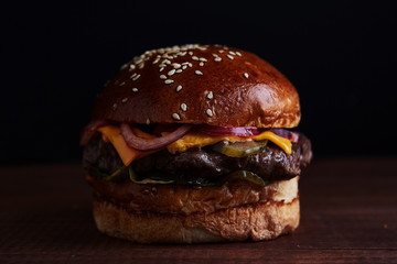 Burger against black background.