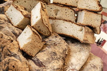 Fresh baked bread on a bakery table. Bread and wine in a traditional Mediterranean cuisine. Italian and French authentic loaves of homemade bread. 