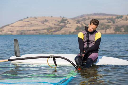 Young man preparing for windsurfing. - Powered by Adobe