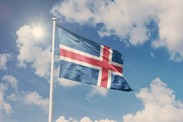 Flag of Iceland, National symbol waving against cloudy, blue sky, sunny day