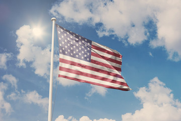 Flag of USA, National symbol waving against cloudy, blue sky, sunny day