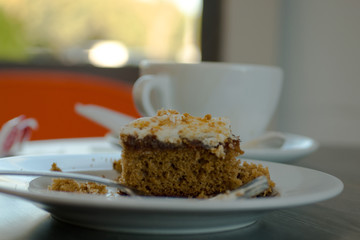  Fresh serving of carrot cake with cup of coffee in background