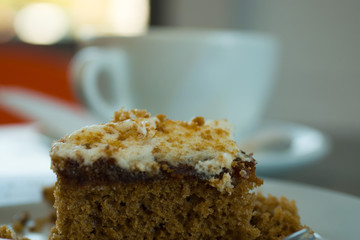  Fresh serving of carrot cake with cup of coffee in background