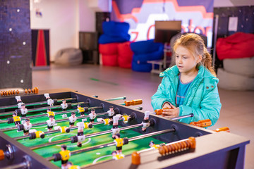 Fototapeta premium Joyful and gambling girl plays table football