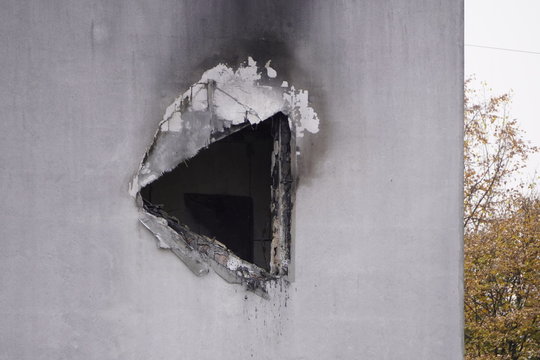 hole in the concrete wall after the fire, smoke soot on the light paint, the need for repair after the fire, restoration