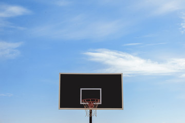 Sports basketball basket for balls on the background of blue sky with clouds.