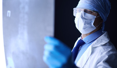 Fototapeta premium Young doctor looking X-Ray image on isolated white background