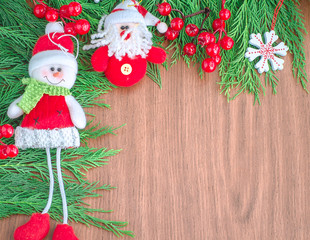 Green spruce branches. Brown wooden background. White, red, multi-colored Christmas toys. Decorations for Christmas tree made of wood and ceramics. Festive fun concept. Congratulatory backdrop. 