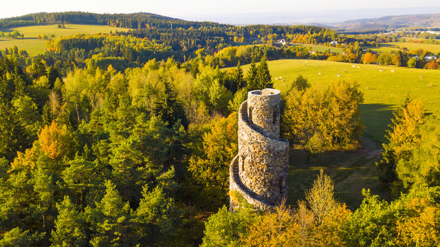 Aerial view of stone lookout tower in Krasno inside forest Slavkovsky les. Beautiful tourist landmark and nature landscape from drone view. West bohemia in Czech republic.