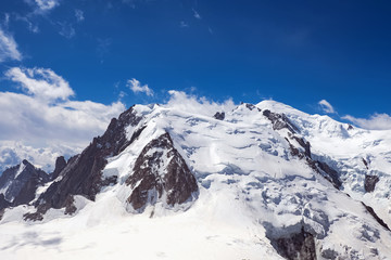 Fototapeta na wymiar Mountain tops in snow against the blue sky