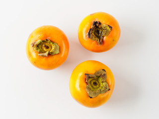 Top view of three persimmon isolated on white background.