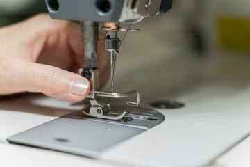 Seamstress sets up sewing machine to make a dress