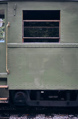 window of an old green metal wagon and golden stirrups