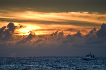 Fototapeta na wymiar Sea fishing under dramatic sunset