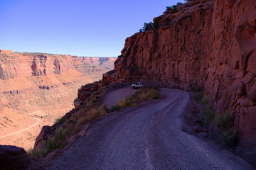 U-turn on a dirt road in desert country with a silver pickup truck