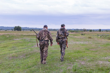 Hunters men with weapons go hunting