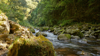 Neat little piles of stones stacked along the river in the Amano Yasukawara shrine in cave, located...
