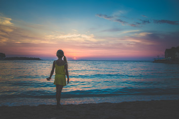 Fototapeta na wymiar child, sea and colorful pink blue sunset