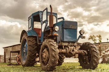 Foto op Canvas An old wheeled tractor stands on an open-air farm © Дмитрий Ногаев