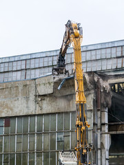 Fototapeta premium wall dismantling for factory reconstruction with industrial crushing shears
