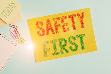 Conceptual hand writing showing Safety First. Concept meaning used to say that the most important thing is to be safe Cardboard and writing equipment placed above pastel backdrop