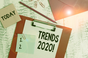 Word writing text Trends 2020. Business photo showcasing general direction in which something is developing or changing Clipboard paper sheet pencil note envelope clips notepad wooden background
