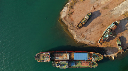 Aerial photo of shipwreck abandoned to rust in industrial bay of Elefsina, Attica, Greece