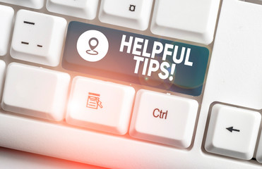 Writing note showing Helpful Tips. Business concept for advices given to be helpful knowledge in life White pc keyboard with note paper above the white background