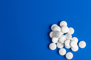 white round pills scattered blue background, chaotically scattered.