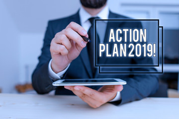 Conceptual hand writing showing Action Plan 2019. Concept meaning proposed strategy or course of actions for current year Male human wear formal clothes present use hitech smartphone