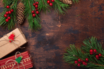 Gift boxes and fir tree branches on wooden background. Christmas greeting card. Top view. Copy space - Image