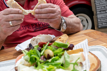 Man eats a healthy Mediterranean food. Italian food on a wooden board.