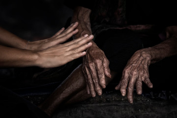 Hands skin of the old woman and a young girl on black