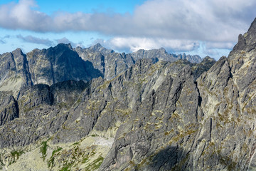 View of rocky mountain ridges in the summer season, over which dark clouds are approaching.