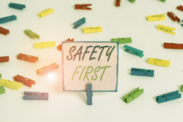 Text sign showing Safety First. Business photo text used to say that the most important thing is to be safe Colored clothespin papers empty reminder white floor background office