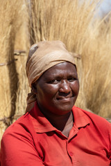 African woman carry grass