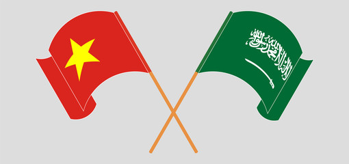 Crossed and waving flags of Vietnam and Kingdom of Saudi Arabia