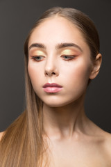 Fototapeta premium Beauty face portrait of young woman. Beautiful model, girl with perfect fresh clean skin. Perfect make up Care Concept. Evening make-up. Black background.