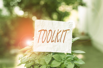 Conceptual hand writing showing Toolkit. Concept meaning set of tools kept in a bag or box and used for a particular purpose Plain paper attached to stick and placed in the grassy land