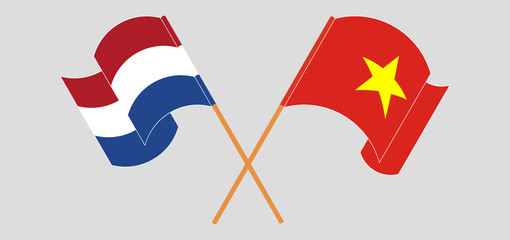 Crossed and waving flags of Vietnam and Netherlands