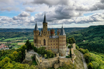 Fototapeta na wymiar Aerial panorama of Burg Hohenzollern (Hohenzollern castle) with hills and villages surrounded by forests with beautiful foliage